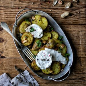 Rustic baked potato with cheese on a wooden table, perfect for a hearty homemade meal.