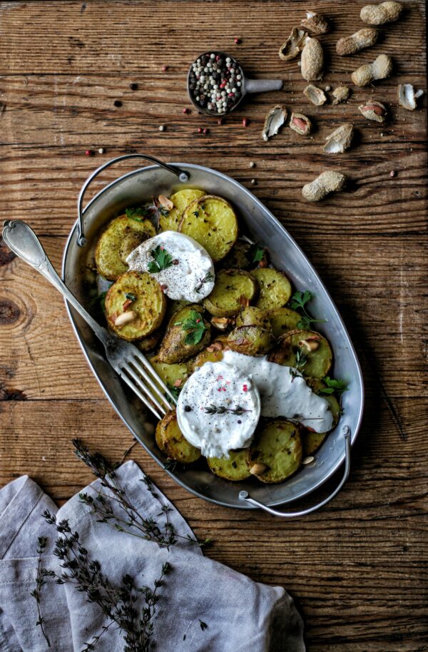 Rustic baked potato with cheese on a wooden table, perfect for a hearty homemade meal.