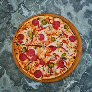 Overhead shot of a pepperoni pizza on a marble surface, perfect for food photography.