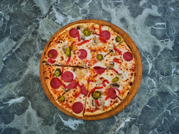 Overhead shot of a pepperoni pizza on a marble surface, perfect for food photography.