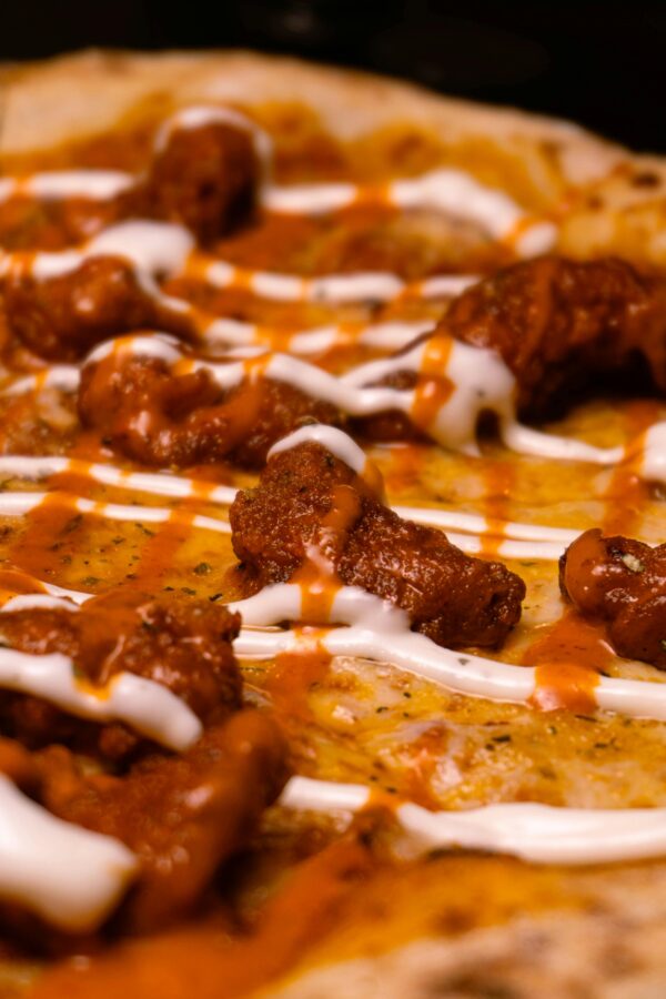 Delicious buffalo chicken pizza with cheese and sauce in a close-up shot.