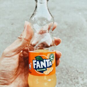 Close-up of a hand holding a Fanta bottle outdoors in Talgar, Kazakhstan.