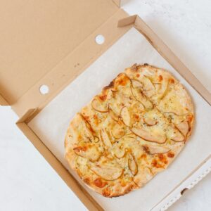 Overhead shot of a freshly baked mushroom pizza in a cardboard delivery box.